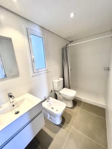 uma casa de banho branca com um WC e um lavatório em Apartamento centrico em Minas