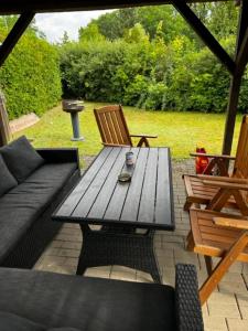 een houten tafel en stoelen op een patio bij Haus Lies in Rehfelde