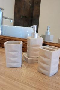 a bathroom with two soap dispensers and a sink at La Maisonnette de l Espace Themis, piscine partagée in Saint-Germain-de-Salles