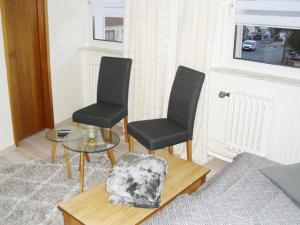 a living room with two chairs and a glass table at Ferienzimmer Am Stadtrand in Dwasieden