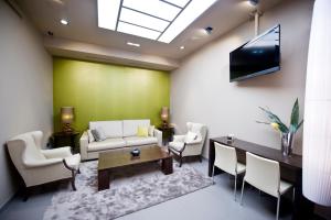 a living room with a couch and a tv on a wall at Hotel San Pedro in Langreo