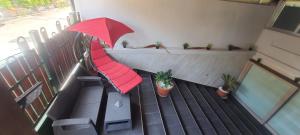 balcón con sombrilla roja y macetas en B&B Gianni en Capodrise