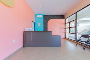 um escritório com paredes cor-de-rosa e azul e uma secretária em Sans Hotel Berau Square em Tanjungredep
