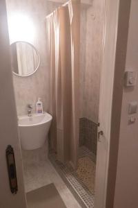 La salle de bains est pourvue d'un lavabo et d'une douche avec un miroir. dans l'établissement #On The Rocks, à Ouranoupoli