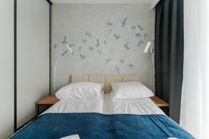a bedroom with two beds with blue birds on the wall at Apartament BIRDS SurfingBird Dźwirzyno in Dźwirzyno