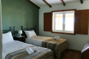 1 dormitorio con 2 camas y ventana en Monte da Casa Nova - Jul and Ago only 7 days stays check-in and check-out on Saturdays, en Vale de Água