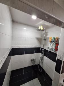 a bathroom with a shower with black and white tiles at Apartman Magic Sauna,Jakuzzi,Kino in Livno