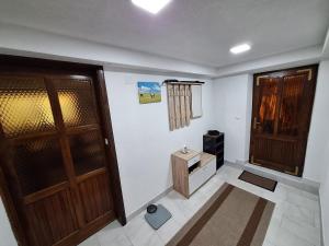 a room with two wooden doors and a small table at Apartman Magic Sauna,Jakuzzi,Kino in Livno