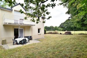 eine Terrasse mit einem Tisch und Stühlen im Hof in der Unterkunft Butterfly - Appartement avec jardin in Miniac-Morvan