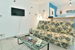 ein Wohnzimmer mit einem Sofa und einem Glastisch in der Unterkunft Butterfly - Appartement avec jardin in Miniac-Morvan