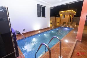 een binnenzwembad met een glijbaan in een hotelkamer bij Executive Studio Apartment, East Airport in Accra