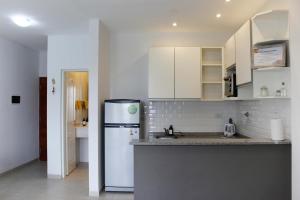 a kitchen with white cabinets and a refrigerator at Dpto en Costanera, excelente ubicación in Corrientes