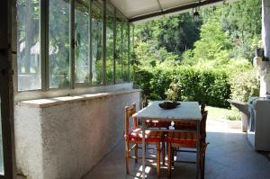 een patio met een tafel en stoelen en een raam bij Casa Millefiori in Bagni di Lucca