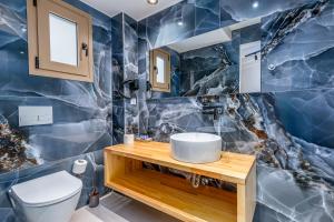 a blue marble bathroom with a toilet and sink at Anasa Corfu in Benitses