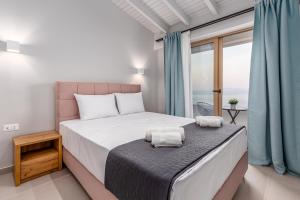 een slaapkamer met een bed met twee handdoeken erop bij Anasa Corfu in Benitses