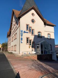 a white building with blue writing on the side of it at Hotel Garni Eschenbach in Hildburghausen