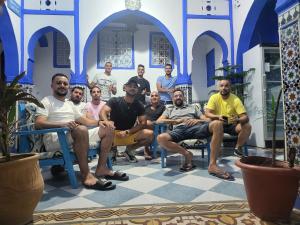 un gruppo di uomini seduti sulle sedie in una stanza di Riad Mauritania a Chefchaouen