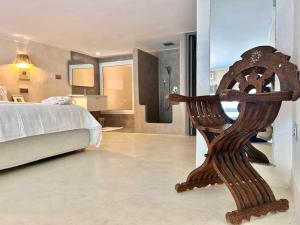 a bedroom with a bed and a wooden chair at The Cliff Appartment in Dar Mimoun Bey