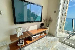 a living room with a large television on a wall at The Cliff Appartment in Dar Mimoun Bey