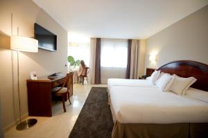 a hotel room with a bed and a desk at Hotel San Pedro in Langreo