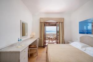 ein Hotelzimmer mit einem Bett und einem Schreibtisch mit Aussicht in der Unterkunft Hotel Punta Negra in Alghero + 37 Fotos