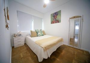 Un dormitorio blanco con una cama y un espejo. en Benalmadena Alay Pool & Beach, en Benalmádena 36 fotos más