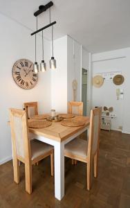 Una mesa de comedor con sillas y un reloj en la pared. en Benalmadena Alay Pool & Beach, en Benalmádena