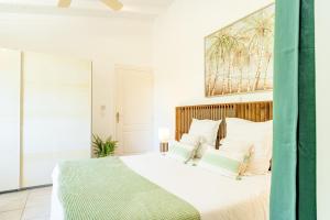 1 dormitorio con 1 cama grande con sábanas y almohadas blancas en Villa Margaux en Grand-Bourg