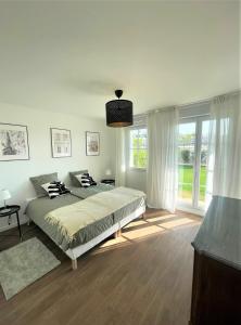 a bedroom with a bed and a large window at Appartement avec jardin près de Disneyland in Serris