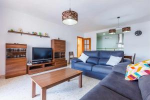 a living room with a blue couch and a coffee table at Apartamento Azucarera Beach Torre del Mar in Torre del Mar