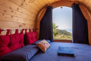Bett in einem Zimmer mit Fenster in einer Hütte in der Unterkunft Terreditusa - Bungalow Lavanda in Tusa