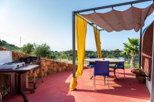 une terrasse avec une table et des chaises sous une tente dans l'établissement Terreditusa - Bungalow Lavanda, à Tusa