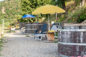 eine Terrasse mit Stühlen und einem Tisch mit einem Sonnenschirm in der Unterkunft Terreditusa - Bungalow Lavanda in Tusa