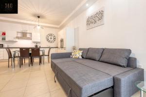sala de estar con sofá y cocina en Wonderful, designer 2BR home with large Sofa & TV by 360 Estates, en San Julián