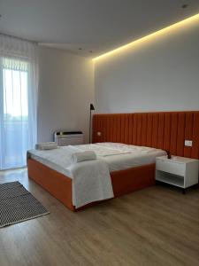 um quarto com uma cama grande e uma janela em Hotel Restaurant Natyra e Qetë em Lezhë