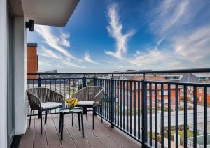 a balcony with two chairs and a table with flowers on it at I LOVE SYLT Hotel Terminus ADULTS ONLY in Westerland (Sylt)