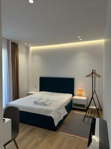 a bedroom with a bed with a blue headboard and a table at Natyra e Qetë Hideaway in Lezhë +82 photos