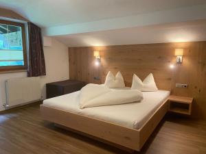 Schlafzimmer mit einem Bett mit weißer Bettwäsche und einem Fenster in der Unterkunft Appartementhaus Nadine in Längenfeld