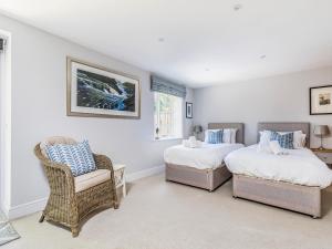 a bedroom with two beds and a chair in it at Pass the Keys Charming Cottage with Garden in Chichester