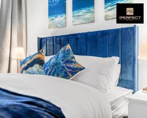 1 dormitorio con cabecero azul y cama con almohadas en Glasgow Airport Luxury Apartment By Your Perferct Stay Short lets Glasgow en Paisley