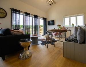 a living room with a couch and a table at Luxury Barn Conversion with Hot Tub- 'Blackbird' in Ab Lench