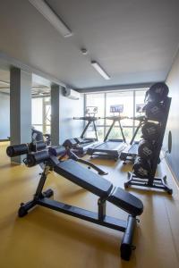 a gym with several tread machines in a room at Nauji apartamentai su šildomu baseinu, sporto sale, vaikų kambariu, work zona in Palanga