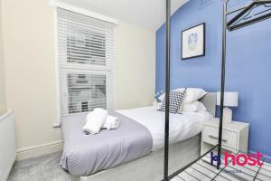 a bedroom with blue walls and a bed with white pillows at Host Liverpool - Chic family spot, near Anfield & centre in Liverpool