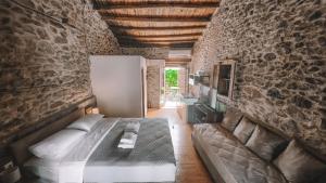 a bedroom with a bed and a stone wall at The Cellar Studios - by Avelink in Spata