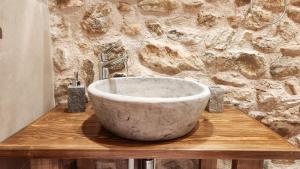 a large stone tub sitting on a wooden table in a bathroom at The Cellar Studios - by Avelink in Spáta