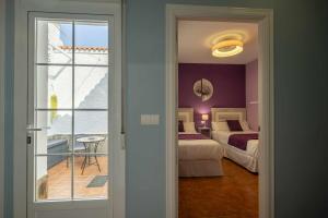 a room with two beds and a view of a balcony at Casa Rural La Posada del 42 in Carrascalejo