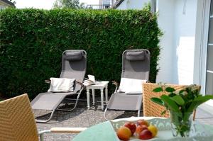 two chairs and a table with fruit on a patio at Strandperle 9, PP außen in Zingst