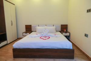 um quarto com uma cama branca com um laço em Balishira Resort Ltd. em Sreemangal
