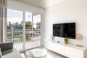 salon z telewizorem i dużym oknem w obiekcie A&N Seafront Torre del Mar w mieście Torre del Mar