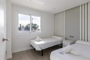 sala szpitalna z dwoma łóżkami i oknem w obiekcie A&N Seafront Torre del Mar w mieście Torre del Mar
